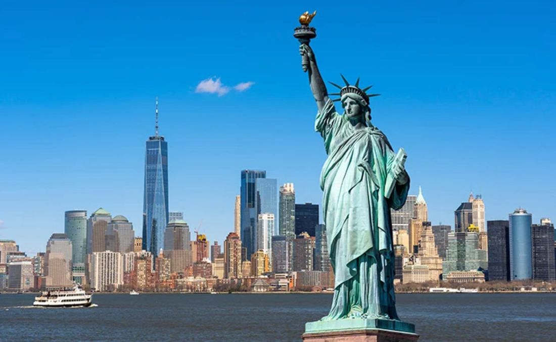 The Statue of Liberty in front of the Lower Manhattan skyline and One World Trade Center