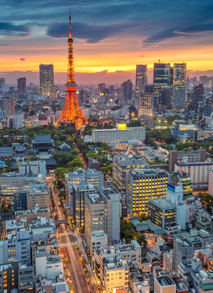 Tokyo Tower lit up at dusk above the city