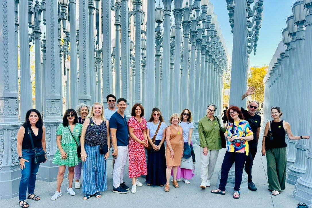 Claudia with a group among the rows of antique street lamps of the Urban Light installation at LACMA